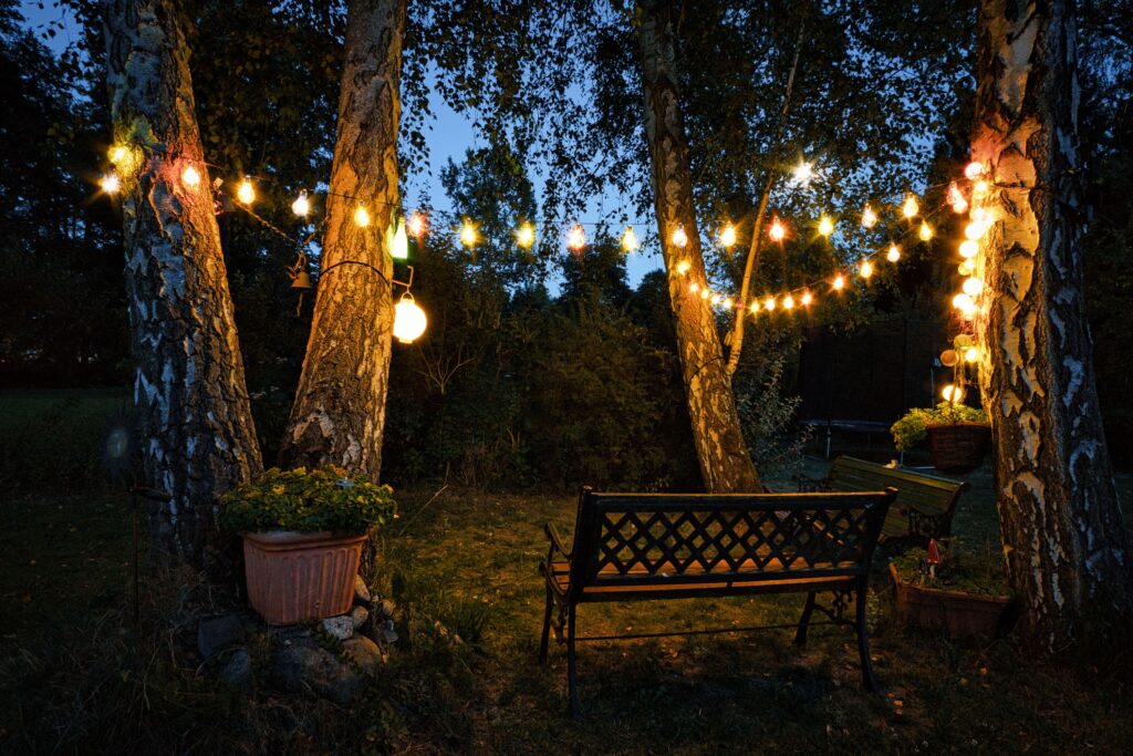 Eine Bank und eine Lichterkette in einen Garten