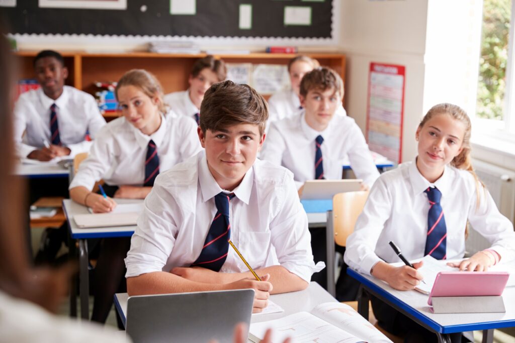 Schüler einer Privatschule hören der Lehrerin zu