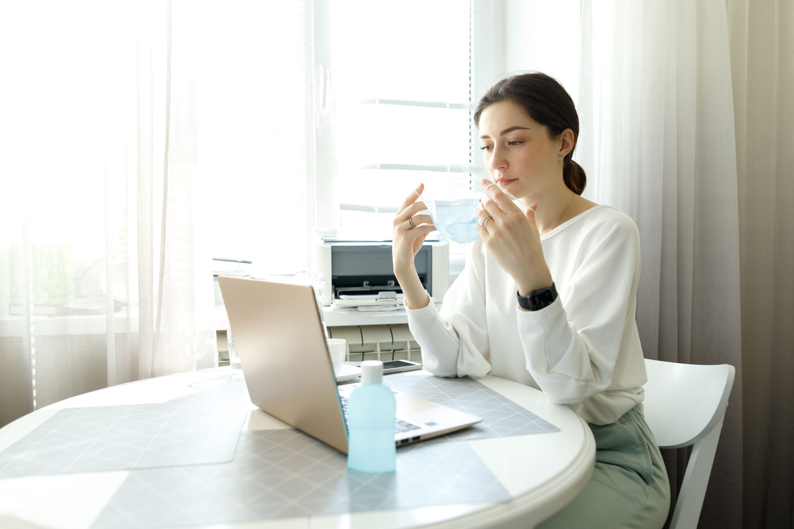Teilnehmerin bereitet sich auf eine E-Learning Hygiene-Einheit vor und setzt eine Maske auf