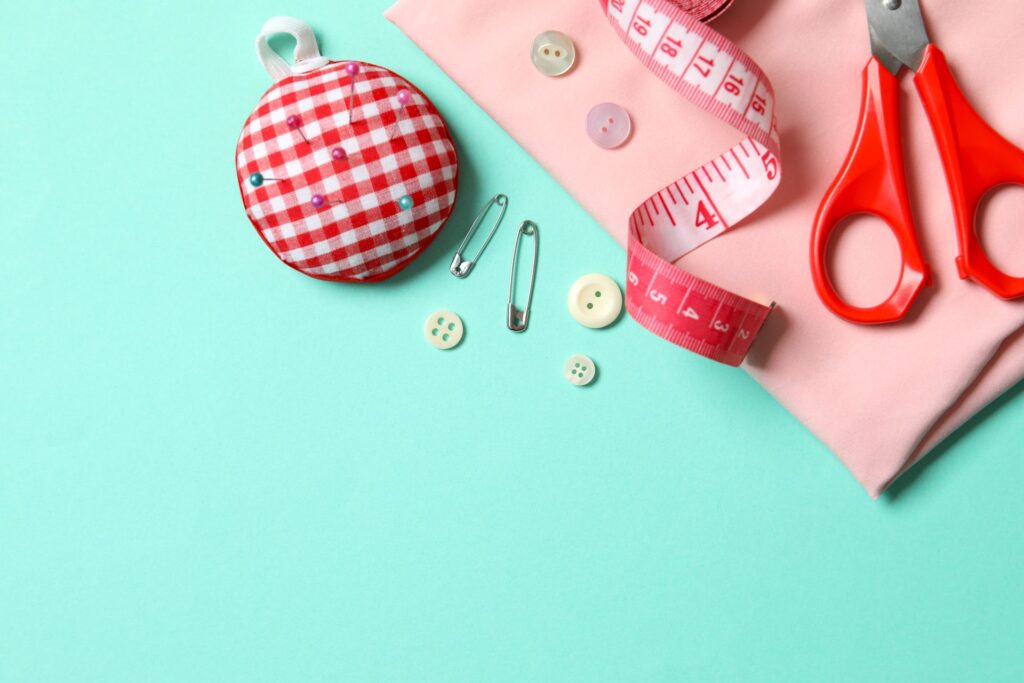 Nähzubehör mit Knöpfen, Schere und Maßband als Materialgrundlage, um Buttons selbst gestalten zu können